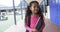 In a school courtyard, a young Hispanic girl smiles brightly