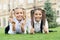 School friends formal clothes relaxing on green grass, child care concept