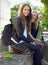 School, friends and portrait of sitting on a wall, outdoor on campus with women and happiness. Social, students and