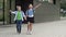 School friendship. A boy and a girl, primary school students, walk out of the school building holding hands.