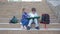 School friendship, little classmates with backpacks sitting on the steps and review book during break in the fresh air