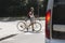 School girl with bike walk in pedestrian crossing in front of a car