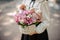 School girl holding a cute wicker basket full of bright pink flowers decorated with a toy
