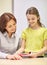 School girl with notebook and teacher in classroom