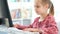 School girl typing on keyboard at desk