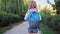 School girl walking along park alley