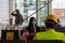 A school girl wearing a medical face mask or face covering while sitting waiting for a bus in a bus station