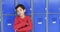 In a school hallway, a young Caucasian boy leans against blue lockers