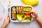 School healthy lunch box with sandwich, cookies, fruits and avocado on white background