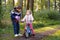 School kid boy, brother put on little preschool sister girl bike helmet on head. Brother teaching happy child cycling