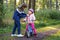 School kid boy, brother put on little preschool sister girl bike helmet on head. Brother teaching happy child cycling