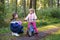 School kid boy, brother put on little preschool sister girl bike helmet on head. Brother teaching happy child cycling