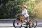 School kid learns to ride a bike in the Park, Portrait of a cute little boy on bicycle,  Child in helmet riding a cycling on the