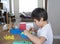 School kid using plastic block counting number, Child boy studying math by colour stack box, Dienes or Montessori classroom