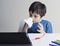 School kid wiping nose with tissue and watching cartoon on tablet,Child stay at home during corona virus home quarantine,E-