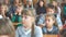 School kids in the classroom sitting at their desks and listen to the teacher