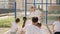 School kids do exercise on sport class with their teacher outdoor. Coach shows how to prepare to the basketball game