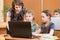 School kids and teacher at laptop in the classroom