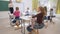 School lesson, young teacher near board conducts cognitive lesson for Smart children at desk in classroom of school