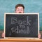 School life full of stress. Teacher peeking out of blackboard. Educator hiding behind blackboard. Man scared beginning