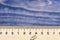 School, mathematics, geometry concept. Wooden ruler close up on blue background. Simple ruler with indicators in form of
