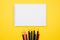School and office supplies flat lay on yellow background top view. Sketchbook, colored pencils layout. Back to school.