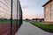 School of preschool building yard with basketball court surrounded with high protective fence