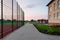 School of preschool building yard with basketball court surrounded with high protective fence