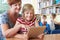 School Pupil With Teacher Using Digital Tablet Computer In Class