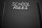 School rules word written on a notepad with blank space. Blank black notepad background