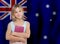 School student girl standing with book on Australian flag background. Education and school in Australia concept