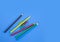 School supplies concepts, Multi-colored pencils and clips on blue background