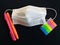 School supplies and medical mask for protection against coronavirus or covid-19 on black background. Protection of students.