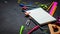 School supplies for school: notepad, pencils, pink ruler, compasses scattered on a gray table. Top view.