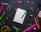 School supplies for school: notepad, pencils, pink ruler, compasses scattered on a gray table. Top view.