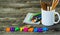 School supplies on wooden background, a mug of crayons and Notepad, word September