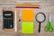 School supplies on a wooden background. View from above. Stickers, pencils, scissors, calculator and notepad on the table.