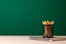 School supplies on wooden desk against green chalkboard