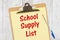 School supply List message on yellow lined paper with a pen on a clipboard