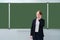 A school teacher talks on a mobile phone near an empty blackboard, copy space for text