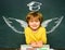 School wings and dream. Happy school kids. School concept. Classroom. Funny little boy pointing up on blackboard. School