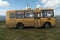 School yellow bus with the inscription on its side -Children - stands on the grass against the beautiful sky