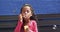 In school, a young African American girl blows bubbles, blue background