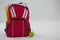 Schoolbag with various supplies and apple on white background