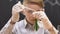 Schoolboy adding liquid into test tube with green substance, observing reaction