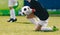 Schoolboy as a soccer goalie catching football ball during a tournament game