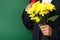 Schoolboy backpack and chrysanthemums on green background