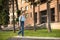 A schoolboy blond, wearing in a shirt and jeans, walks with a kn