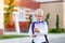 A schoolboy boy with blond glasses with a backpack and a white book is standing at the school. Space for text. Day of knowledge