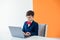 schoolboy boy sitting at a laptop at a desk in a school in a classroom online education room